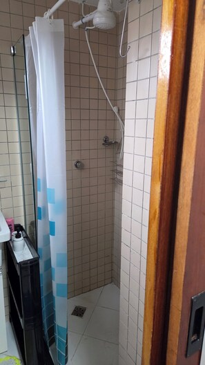 Een douche, handdoeken, zeep, toiletpapier