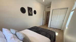 A bedroom with a bed, pillows, a door, and wall decorations. - Single Story Ranch l New Build l RMNP l 3bd 2bath l Game room (Loveland)