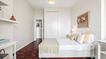 A bedroom with a bed, bedside table, lamp, and a wardrobe.