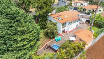 A residential property with a swimming pool, a covered patio, and a view of the neighborhood.