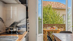 A compact kitchen with a marble backsplash, a stove, and a sink. - Casa Turturella – Vue mer et citadelle au cœur de Calvi (Calvi)