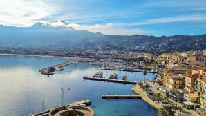 A coastal town with a marina, buildings along the waterfront, and mountains in the background. - Casa Turturella – Vue mer et citadelle au cœur de Calvi (Calvi)