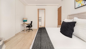 A modern bedroom with a large bed, a desk with a computer, and a view to the hallway. - Mistiq Views in Cabo San Lucas (Cabo San Lucas)