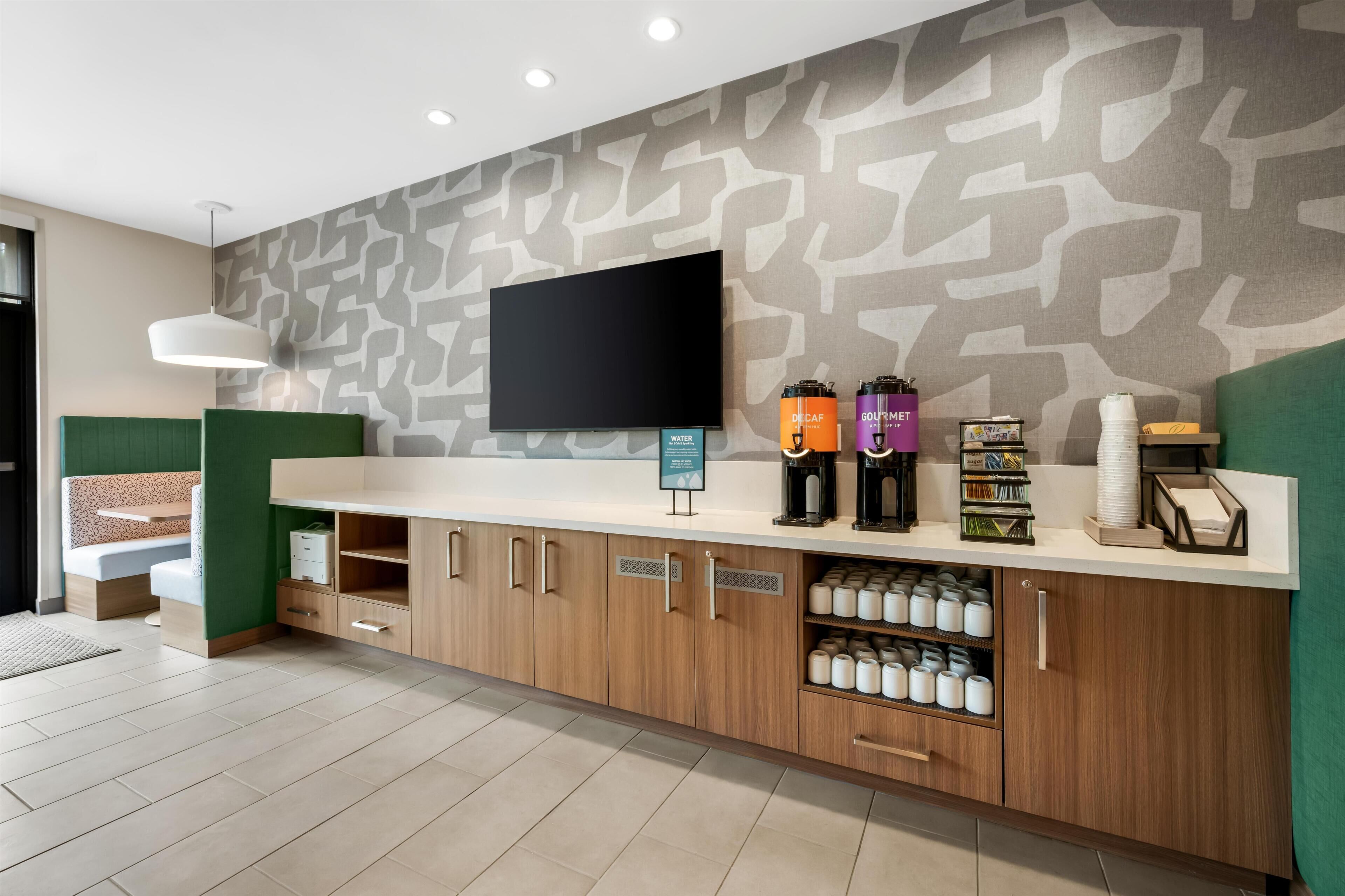 Een receptie met een flatscreen televisie, een koffiehoek en een watervoorziening.