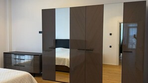 Quarto moderno com cama, guarda-roupa e espelho.