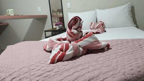 Ein Hotelzimmer mit einem Bett, einem Nachttisch, einem Spiegel und Wanddekoration.
