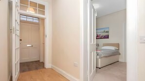 Un dormitorio con cama, mesita de noche y un cuadro en la pared.