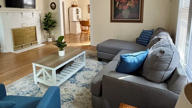 Een woonkamer met een open haard, een televisie, een bank en een salontafel.