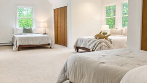 A spacious bedroom with two beds, a wooden wardrobe, and a large window. - Four-Season Lake Winnipesaukee Retreat (Laconia)