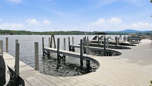 A wooden dock extending into a calm lake with a clear sky above. - Four-Season Lake Winnipesaukee Retreat (Laconia)