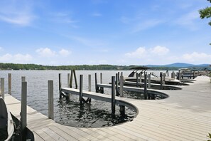 Eine Holzsteg, der sich in einen stillen See erstreckt, über dem sich ein klarer Himmel spannt.