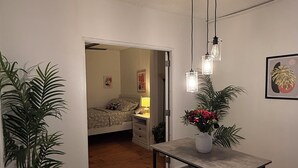 Un comedor con una mesa y sillas, una lámpara colgante y una planta en maceta.
