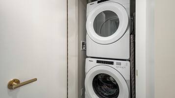 A stacked washer and dryer unit in a white utility room.