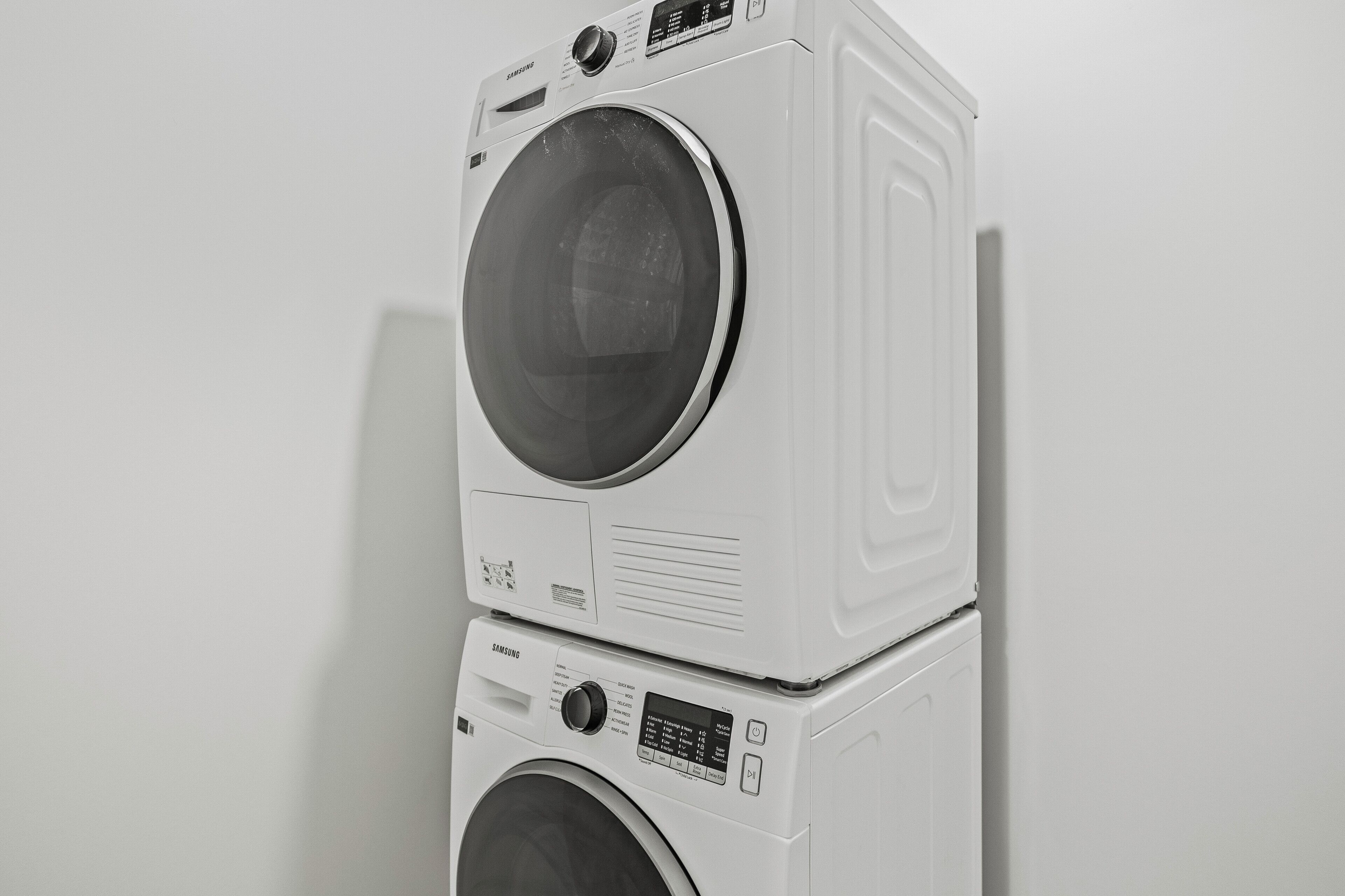A stacked washer and dryer unit with control panels and a power button.