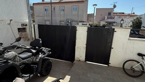 A patio with a folding chair, a motorcycle, and a bicycle.