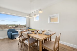 A dining area with a wooden table, chairs, and a view of the landscape. - New for 2026  Rosemerryn , Holiday Home Padstow with breathtaking estuary views (Padstow)