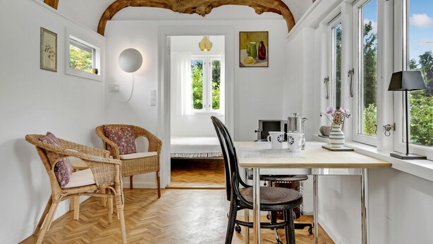 A dining area with wicker chairs, a table with a coffee pot, and a view through a window. - 1 bedroom gorgeous home in Gilleleje (Gilleleje)