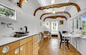 Eine moderne Küche mit Holzschränken, einer integrierten Spüle und einem Essbereich mit Stühlen und einem Tisch.