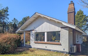A small, single-story house with a white exterior, a brick chimney, and a covered porch area. - 3 bedroom gorgeous home in Kalundborg (Kalundborg)