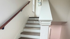 A staircase with wooden steps and white railings. - Modern Stay Near Downtown / Cozy & Clean (San Antonio)