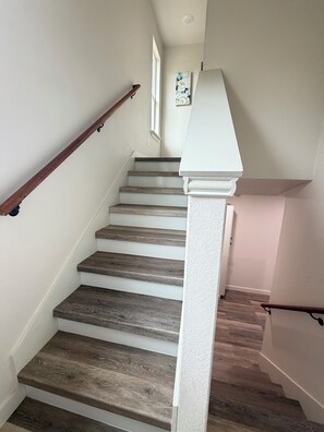 Eine Treppe mit Holzboden und weißen Geländern.