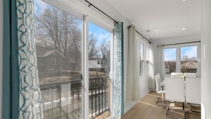 Een modern appartement met grote schuifdeuren, een balkon en een keukenhoek.