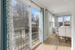A modern apartment with large sliding glass doors, a balcony, and a kitchen area. - Elegant 4BR Lakefront Retreat-Ready For Long-Stay (Antioch)