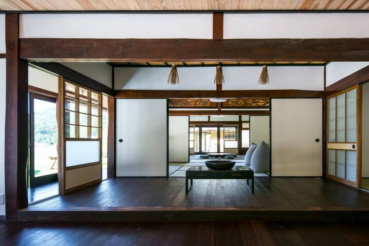 Una habitación japonesa tradicional con suelo de tatami, puertas correderas y una mesa central.