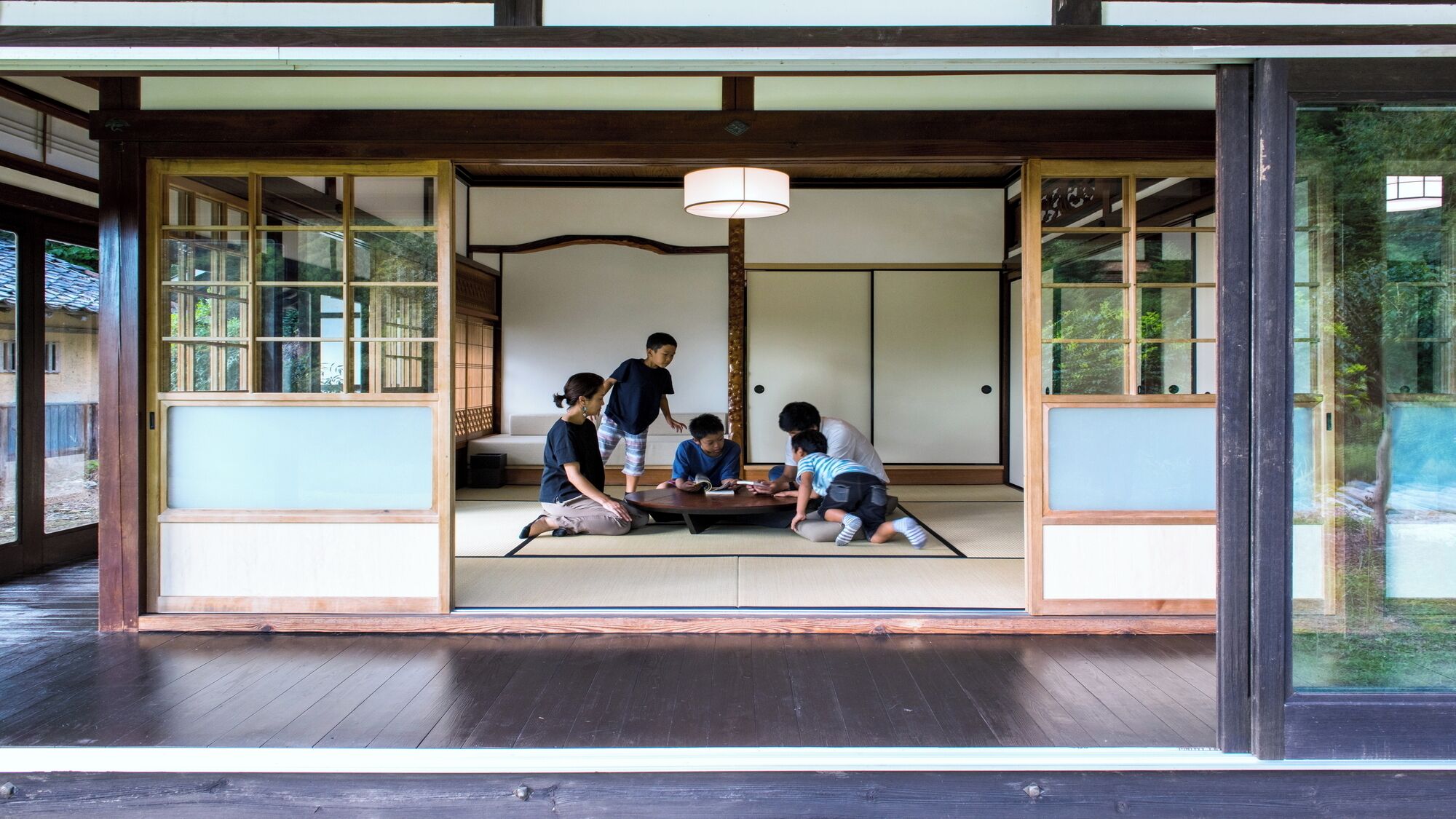 A traditional Japanese room with tatami flooring, sliding doors, and a shoji screen.