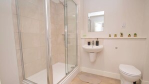 A modern bathroom with a glass-enclosed shower, a pedestal sink, and a toilet. - Stylish 1BR Sanctuary in Hull Centre Near Marina (Kingston upon Hull)