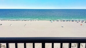 A beach with umbrellas and lounge chairs, a clear sky, and the ocean. - The Palms East 901 | Beachfront | Pools | My Beach Getaways (Orange Beach)