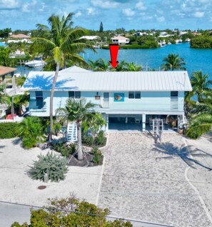 A beachfront property with a large house, a swimming pool, and a view of the ocean. - Water front 5-bedroom house with boat dock in beautiful Marathon (Marathon)