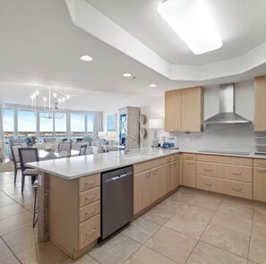 A modern kitchen with a large island, built-in appliances, and a view of the city. - NEW! NEW! NEW! ,TOP OF THE LINE, 3 BED/3 BATH UNIT!ASK ABOUT OUR BEST PRICE! (Orange Beach)