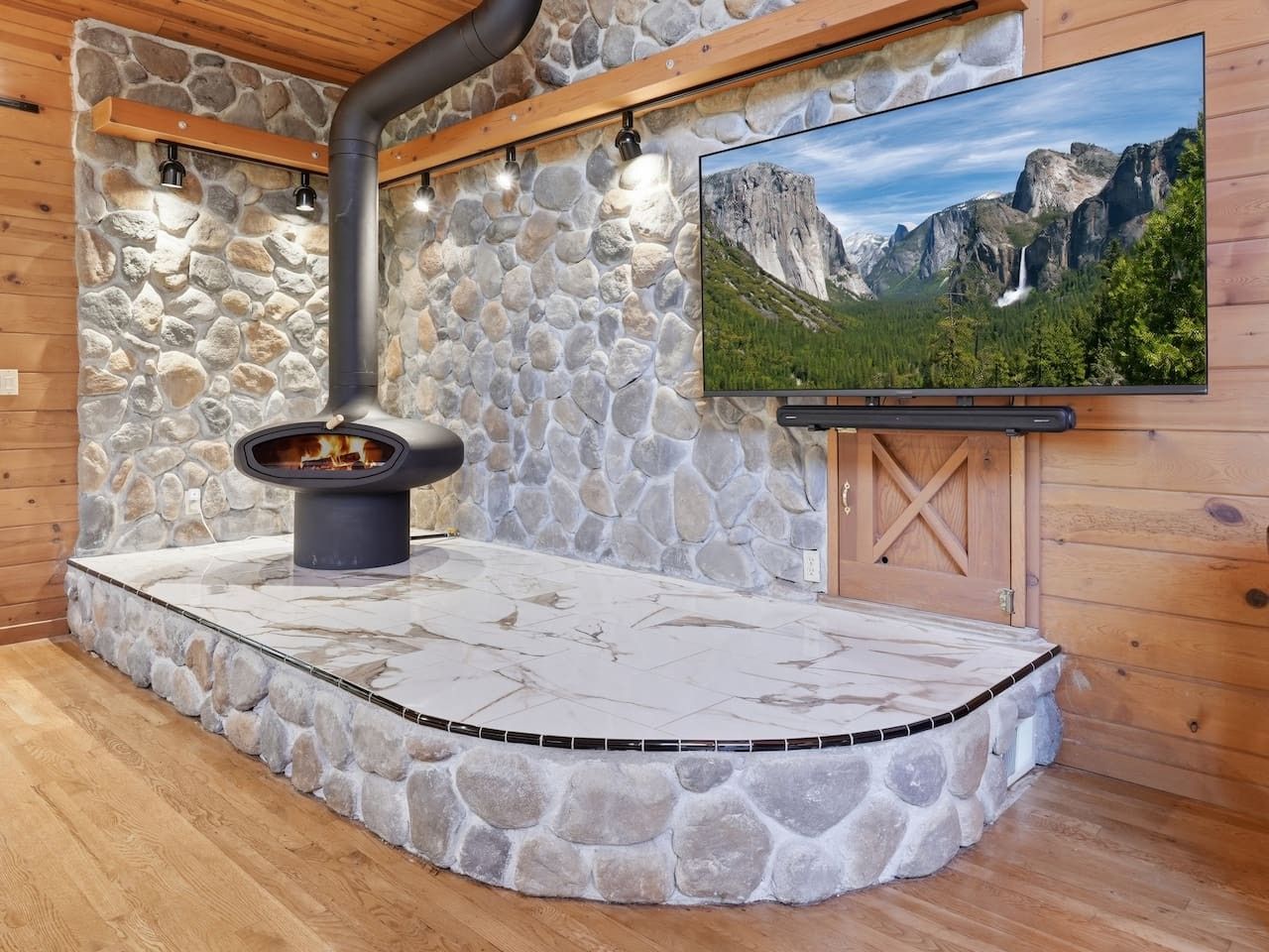 A stone fireplace with a TV mounted on the wall above it.