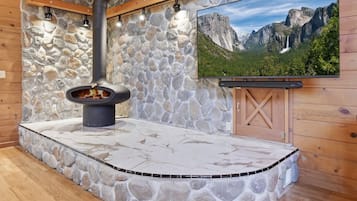 A stone fireplace with a TV mounted on the wall above it.