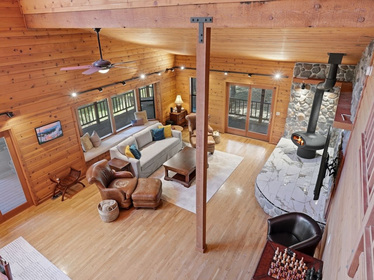 A cozy cabin interior with a fireplace, wooden walls, and a seating area.