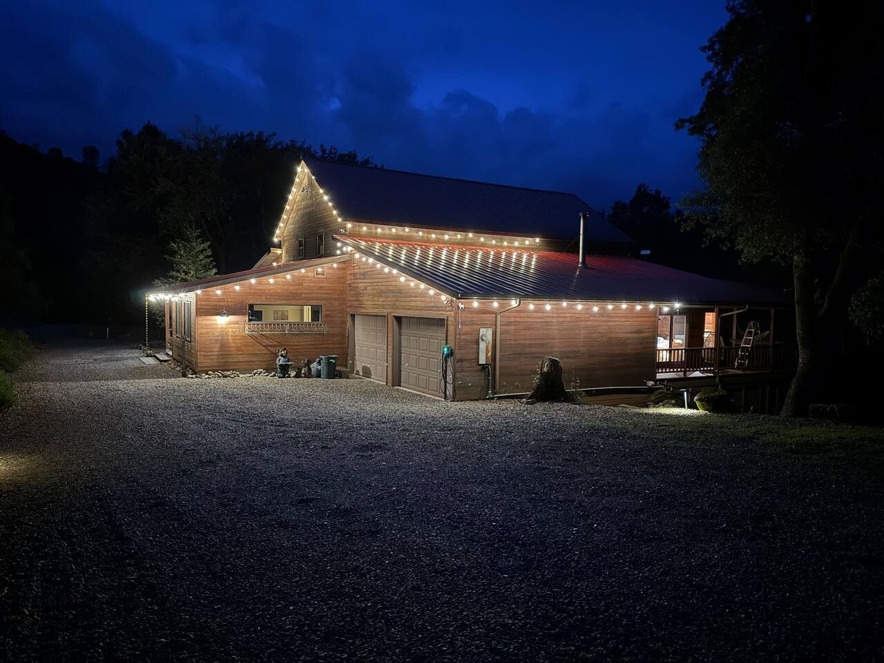 Een gebouw met een schuin dak, een grindpad en een houten terras.