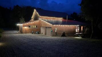 Een gebouw met een schuin dak, een grindpad en een houten terras.