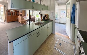 A kitchen with a sink, cabinets, and a dining area with a table and chairs. - 2 bedroom nice home in Sydals (Sydals)
