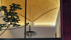 A modern interior with a staircase, a hanging light fixture, and a large window. - Jardin Elvira (Cuernavaca)