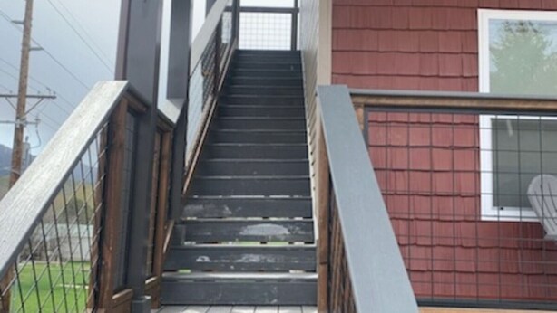 Eine Treppe führt zu einem Gebäude mit einer roten Außenwand und einem Fenster.
