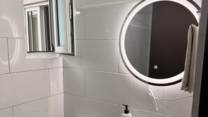 Ein modernes Badezimmer mit Toilette, Waschbecken und Spiegel.