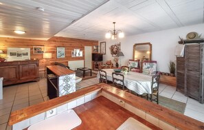 A cozy living room with a wooden ceiling, a dining area with a table and chairs, a TV, and a fireplace. - Lovely home in Arcachon with WiFi (Arcachon)