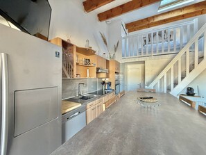 Eine moderne Küche mit integriertem Geschirrspüler, Holzschränken und einer Betonarbeitsplatte.