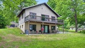 A two-story house with a balcony, a front door, and a small porch area. - Discover Taylor Creek Lodge on Lake Namakagon (Cable)