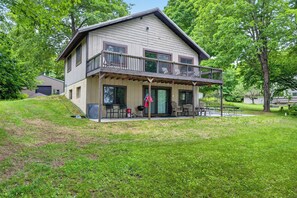 Ein zweistöckiges Haus mit Balkon, Eingangstür und einer kleinen Veranda.