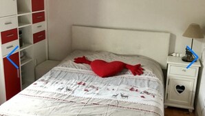 Une chambre à coucher comprenant un lit, une table de chevet, une commode et un élément décoratif mural.