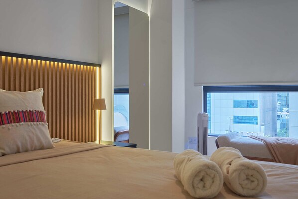 Ein Hotelzimmer mit Bett, Kissen, Handtuch, Fenster und Blick nach draußen.