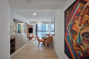 Ein modernes Interieur mit Essbereich, Küche und einem großen abstrakten Gemälde.