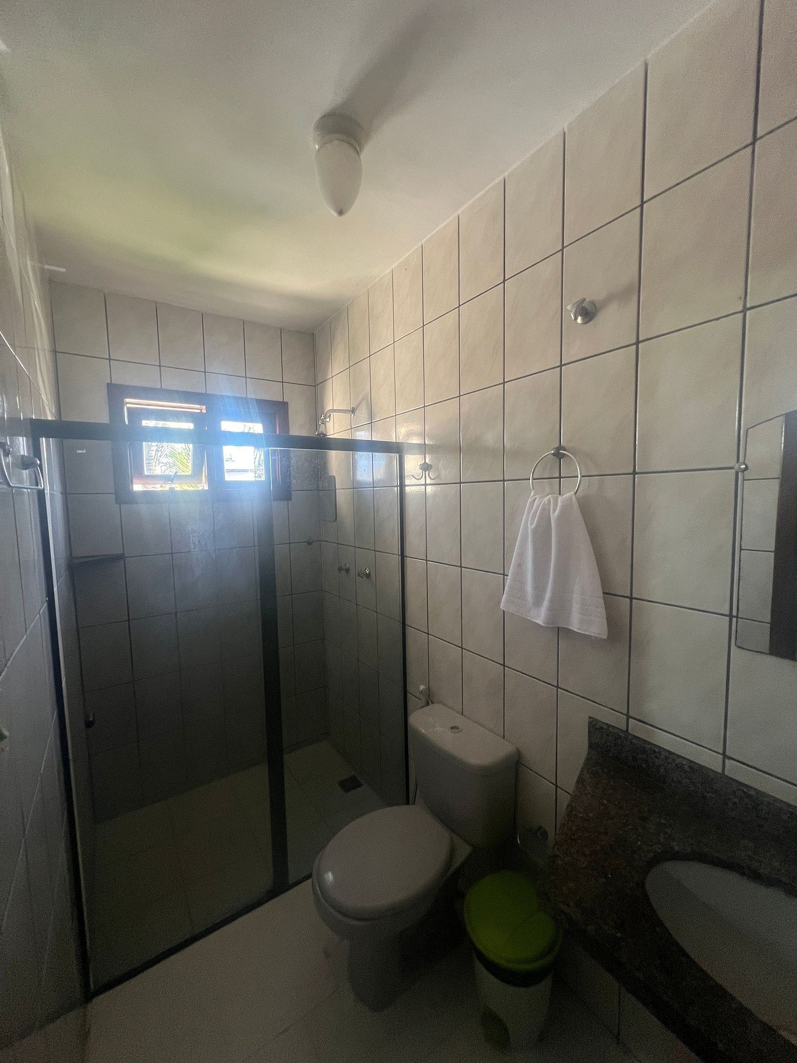 A bathroom with a toilet, shower, and sink.